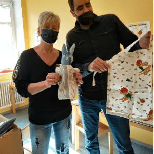 o Schürzen für Kinderhort St. Marien in Lichtenfels. Leiter der AGH bei P&S, Jaouher Jemal und die Leiterin des Kinderhorts, Frau Bittner