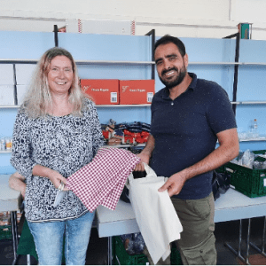 AGH_Lichtenfels_Tragetaschen Schürzen für Kinderhort St. Marien in Lichtenfels. Leiter der AGH bei P&S, Jaouher Jemal und die Leiterin des Kinderhorts, Frau Bittner